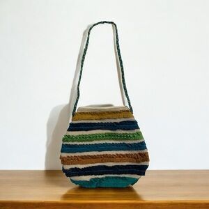Louise Aarong Bangladesh
Small round patch fabric ethnic bag with braided strap.